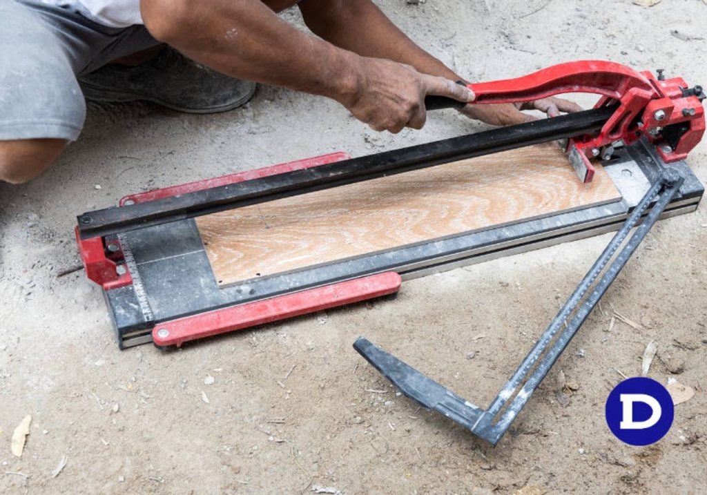 Homem manuseando cortador de pisos de cor vermelha